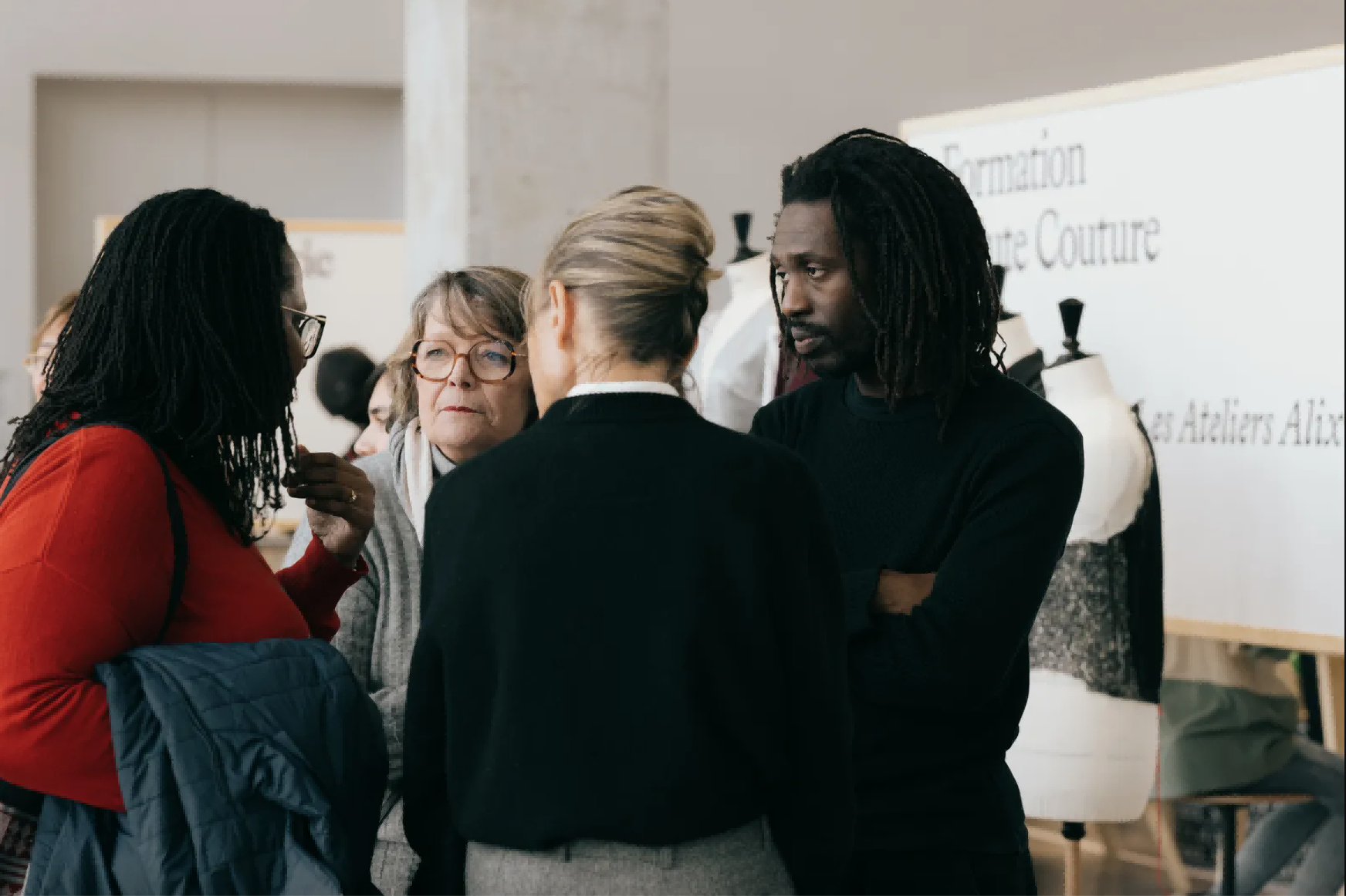巴黎服装学校Ateliers Alix的创办人Mossi Traoré（居右）在校内与众人交流